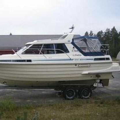 En mørkeblå Bella 9000 Sunmar bådkaleche monteret på en båd. Kalechen dækker hele badns cockpit.